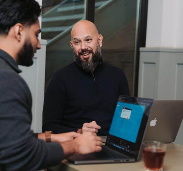 Medewerkers van Atom achter de laptop in overleg