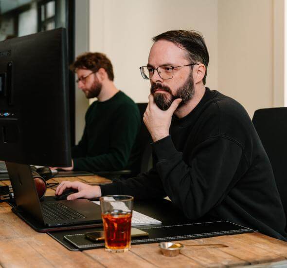 Medewerkers van Atom Rotterdam achter de laptop