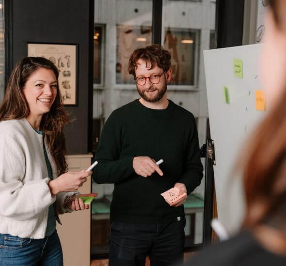 Medewerkers van Atom Rotterdam op een whitebord bezig