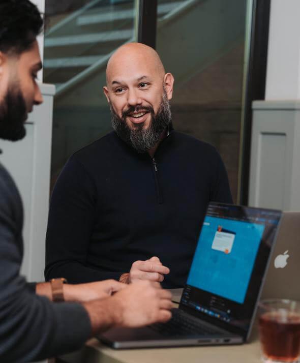 Medewerkers van Atom achter de laptop in overleg