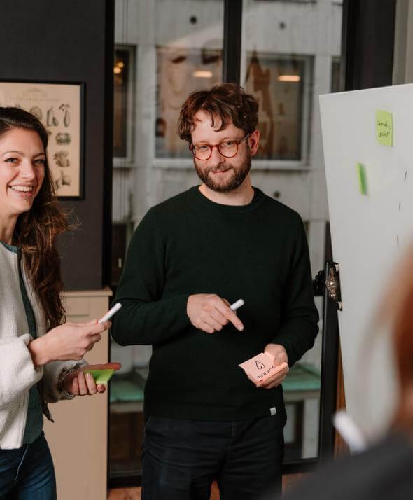 Medewerkers van Atom Rotterdam op een whitebord bezig