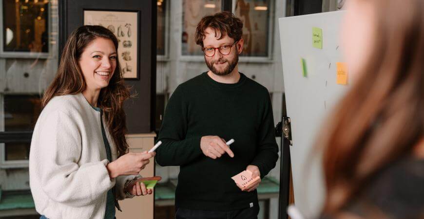 Medewerkers van Atom Rotterdam op een whitebord bezig